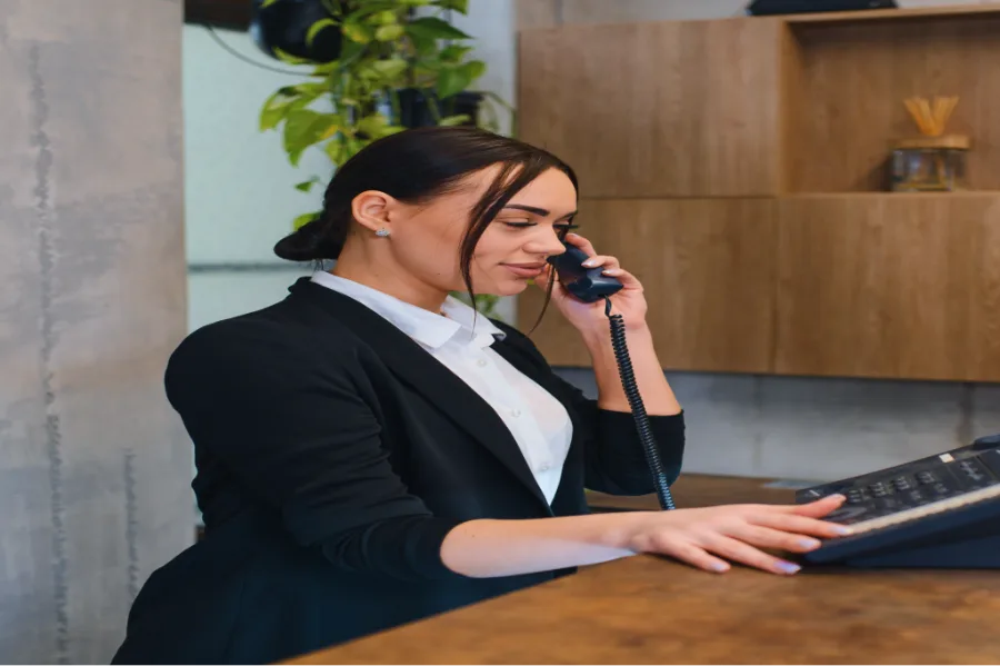 Receptionist answering a desk phone